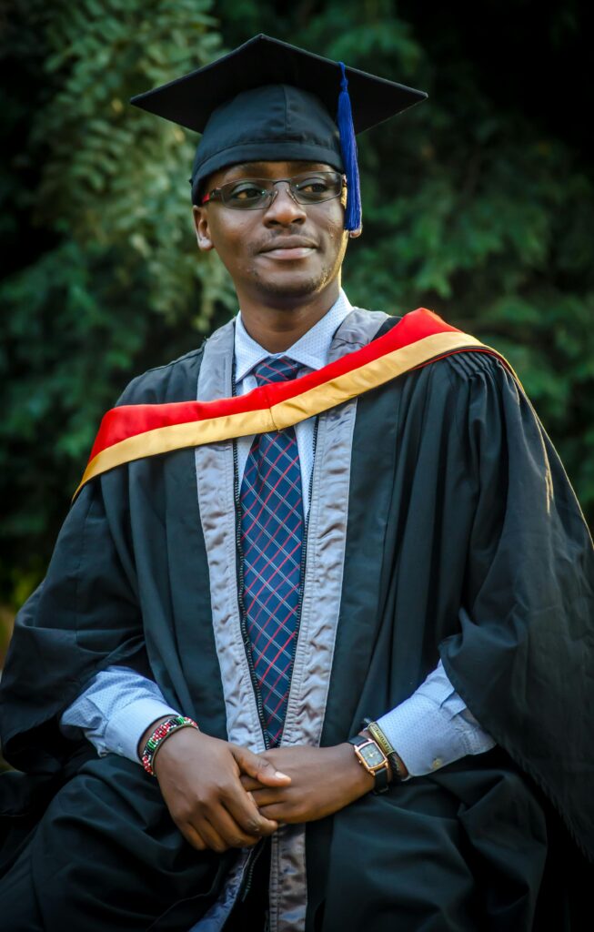 pexels-photo-2259997-2259997 A joyful graduate wearing academic regalia poses outdoors, celebrating success.